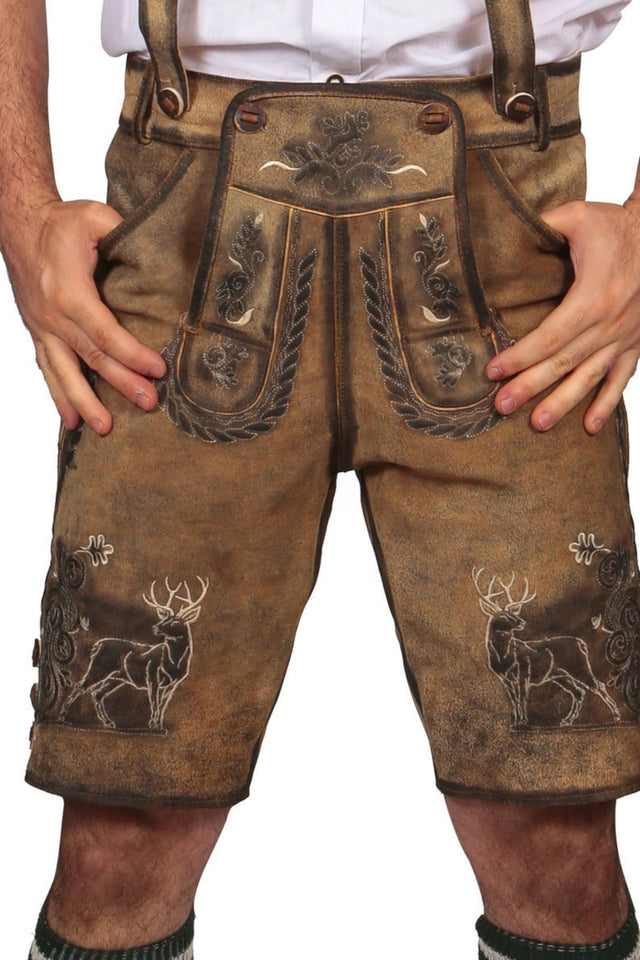 A pair of brown leather Trachten short lederhosen featuring decorative embossing, with front and side pockets and matching suspenders.