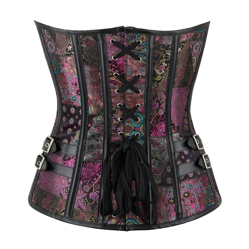 A Victorian-style corset with a multicolor paisley and floral patchwork pattern in purple, pink, and teal, accented by black faux-leather trim, laces, and side buckles, shown against a plain white background.