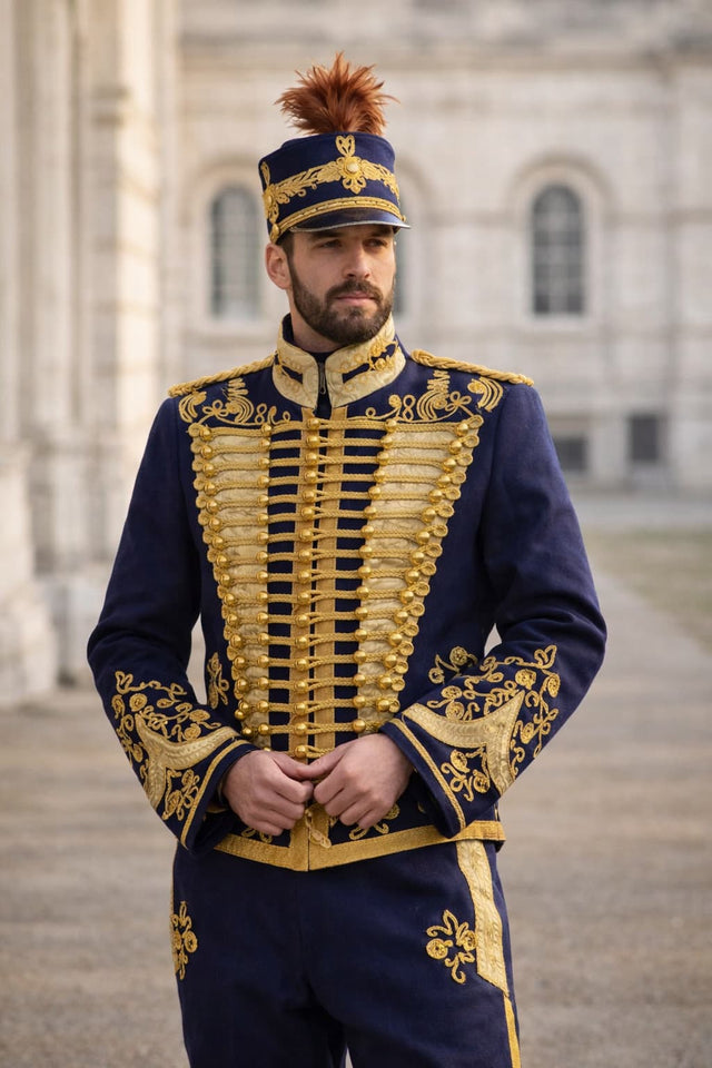 Man in a formal blue and gold uniform standing outdoors.