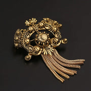 Decorative gold brooch with intricate design on a black background