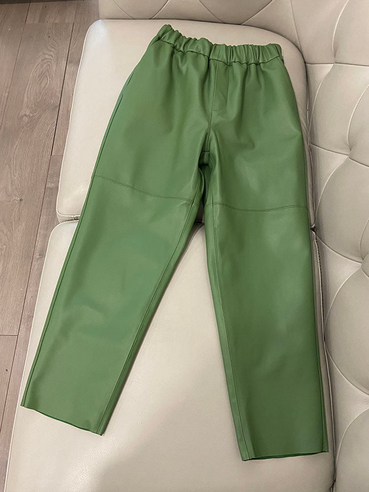 Green pants on a white cushioned chair with a wooden floor background