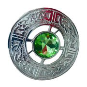 Decorative button with a green gemstone on a beige background