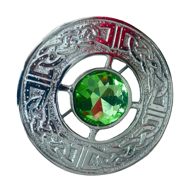 Decorative button with a green gemstone on a beige background