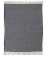 A dark gray rectangular throw blanket with cream-colored fringe on both ends, displayed flat against a white background.