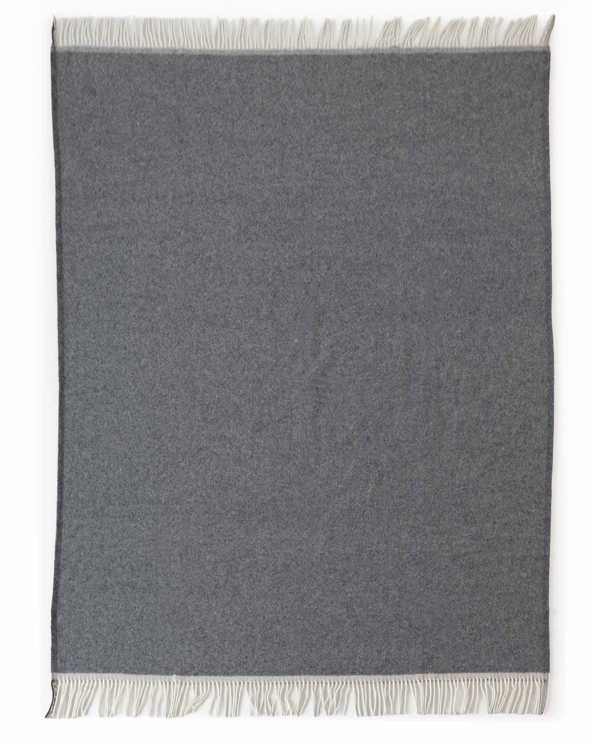 A dark gray rectangular throw blanket with cream-colored fringe on both ends, displayed flat against a white background.