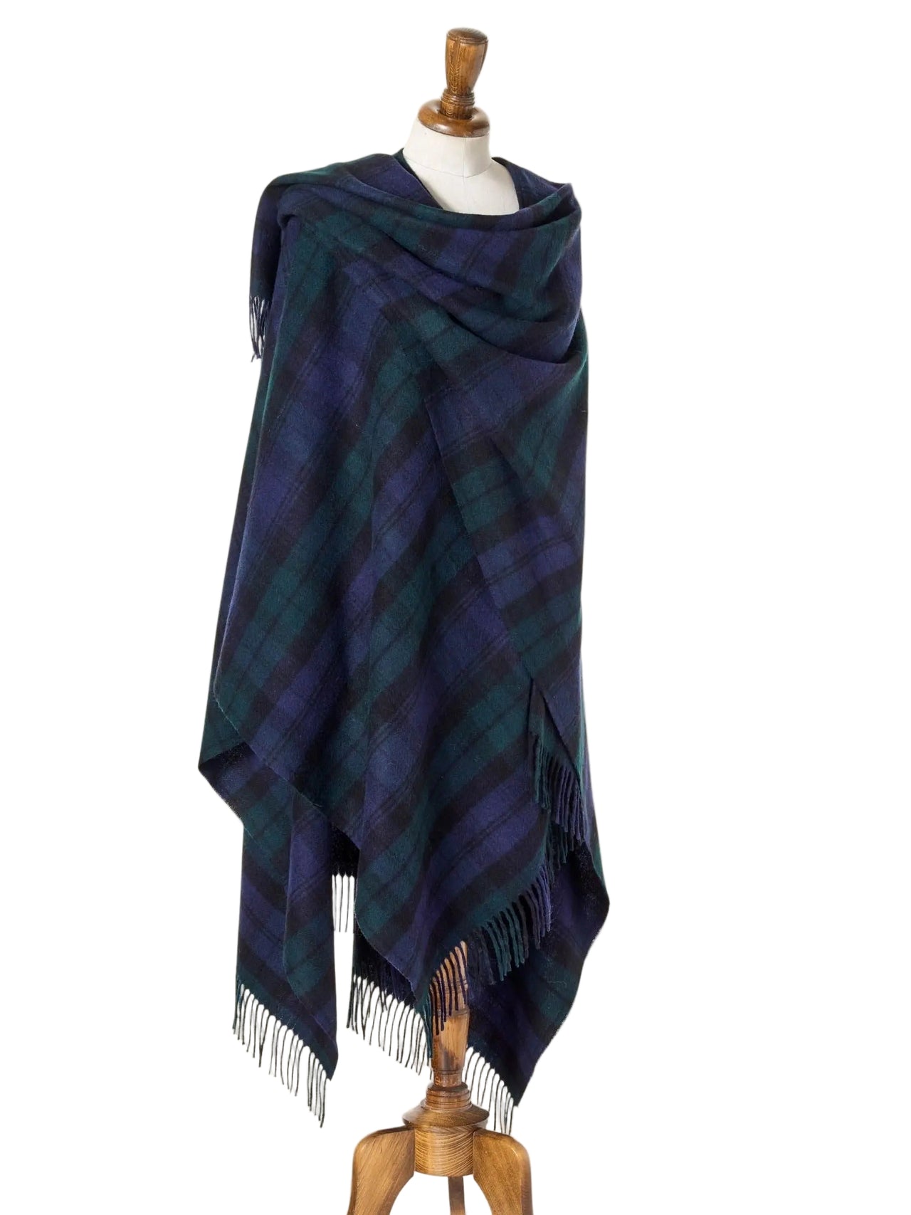 Plaid poncho draped over a mannequin on a beige background