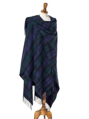 Plaid poncho draped over a mannequin on a beige background