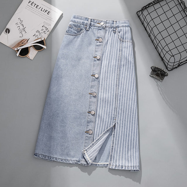 A medium-length denim skirt with high waist and stripe details, displayed with sunglasses, a book, and a metal grid background.