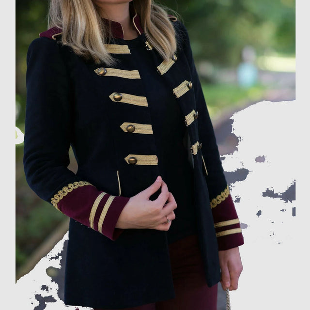 A woman wearing a black military-style blazer with gold embroidery and brass buttons.